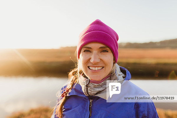 Portrait of woman in pink hat on riverbank at sunset  Morro Bay  California  USA