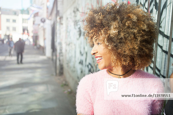 Young woman outdoors  looking away  smiling