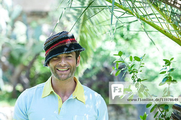 Porträt eines glücklichen Mannes mittlerer Erwachsener mit Hut im Garten