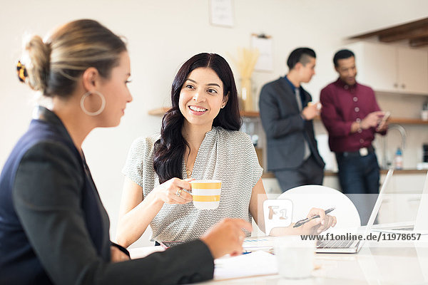 Zwei junge Geschäftsfrauen treffen sich am Schreibtisch