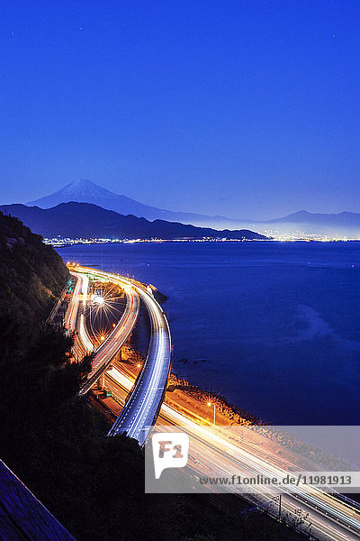 Nächtlicher Blick auf den Berg Fuji und die Autobahn vom Satta-Kamm bei Sonnenuntergang  Präfektur Shizuoka  Japan