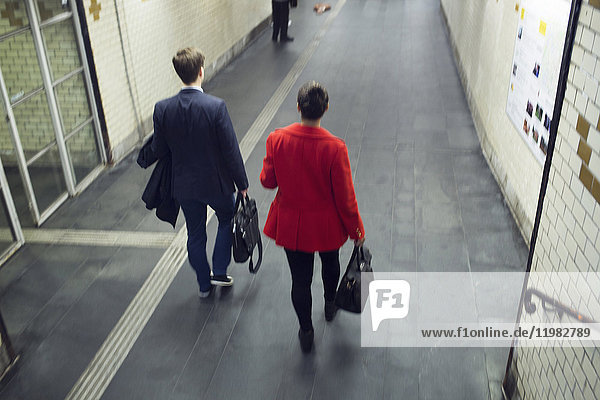 Rear view of man and woman walking at station