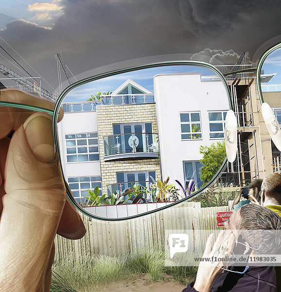 Mann schaut durch eine Brille und stellt sich ein neues Gebäude auf einer Baustelle vor