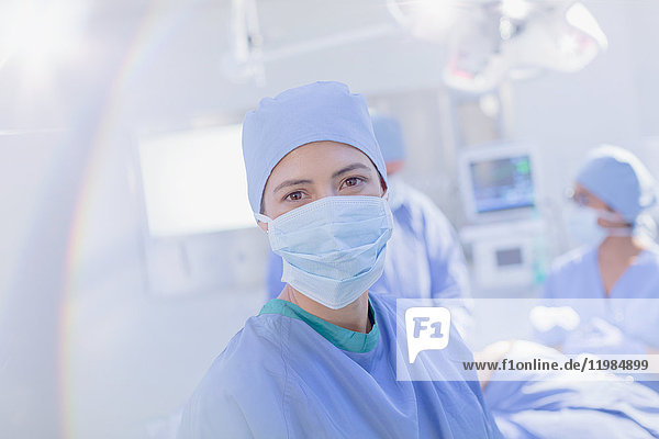Porträt einer selbstbewussten Chirurgin mit chirurgischer Maske im Operationssaal