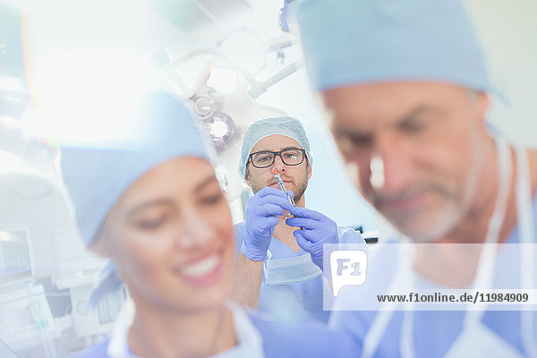Männlicher Anästhesist bereitet Anästhesie-Medikamente in einer Spritze im Operationssaal vor