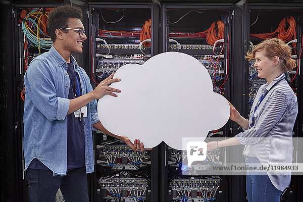 IT technicians holding cloud in server room  cloud computing