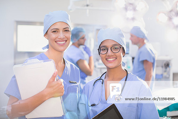 Portrait lächelnde  selbstbewusste Chirurginnen im Operationssaal