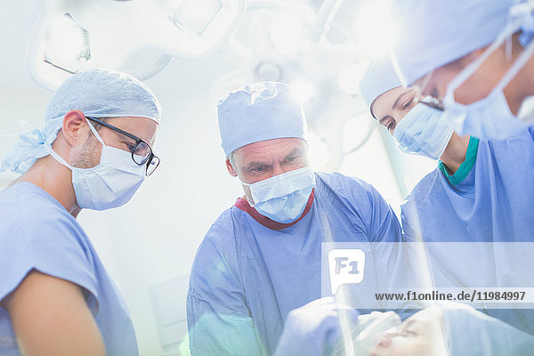 Konzentrierte Chirurgen und Anästhesisten bereiten den Patienten im Operationssaal auf die Operation vor