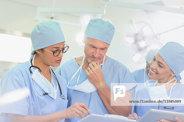 Chirurgen bei der Durchsicht von Papierkram im Operationssaal