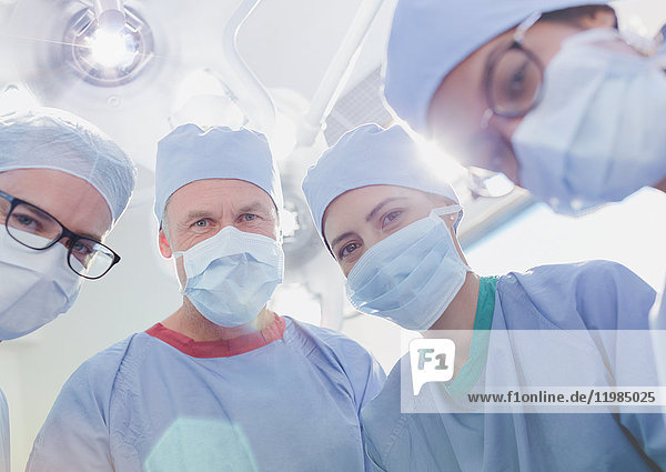 Porträt selbstbewusster Chirurgen mit OP-Masken im Operationssaal