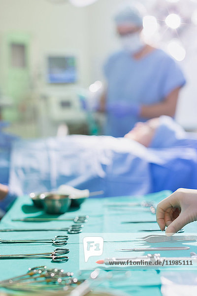 Krankenschwester ordnet chirurgische Instrumente auf einem Tablett im Operationssaal an