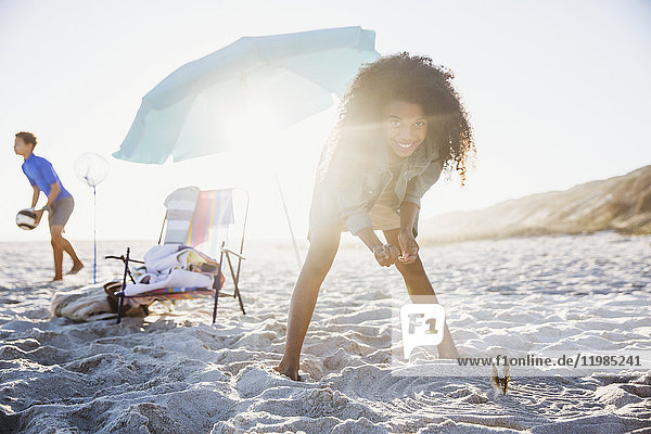 Portrait playful girl playing on sunny summer beach