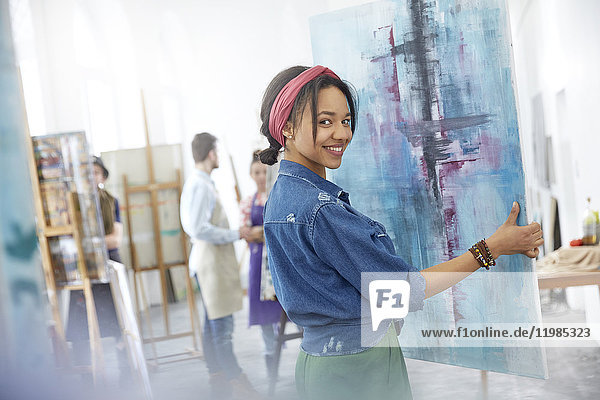 Portrait lächelnde Künstlerin beim Malen im Atelier der Kunstklasse