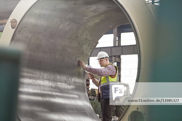 Ingenieur bei der Untersuchung großer Stahlzylinder im Werk