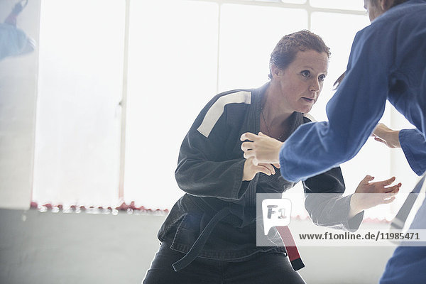 Entschlossene  zähe Frau  die im Fitnessstudio Judo übt.