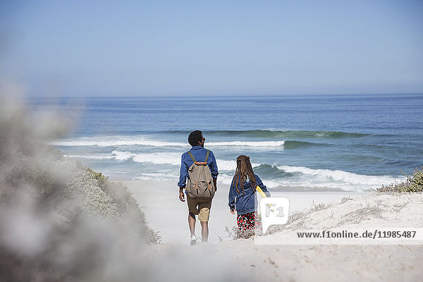 Vater und Tochter wandern mit Boogie-Board am sonnigen Sommerstrand des Ozeans
