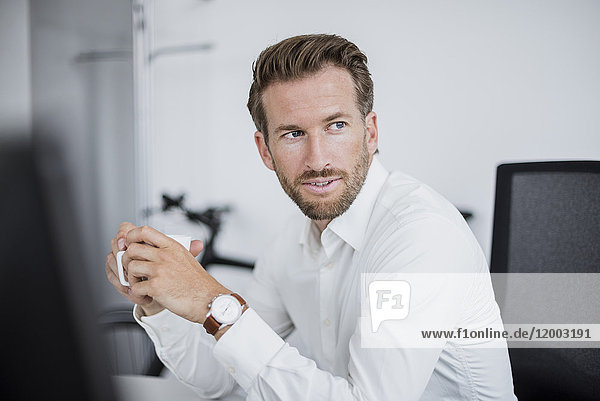 Portrait of businessman with coffee cup in the office