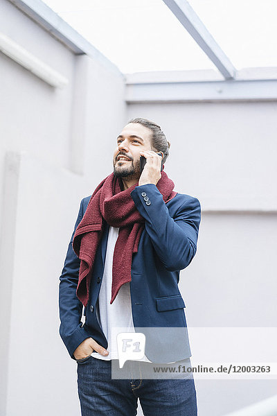 Porträt eines lächelnden Geschäftsmannes am Telefon mit Schal
