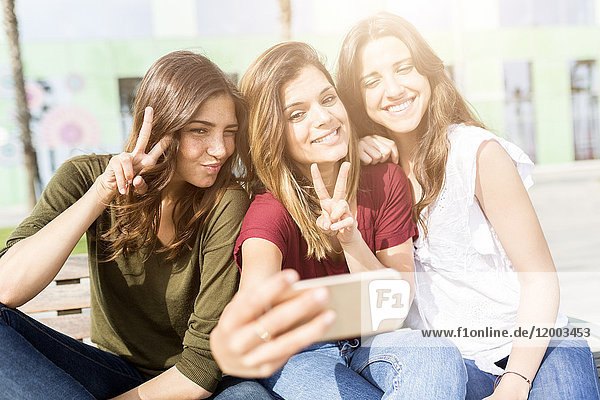 Drei glückliche Freundinnen  die mit einem Selfie nach draußen gehen.