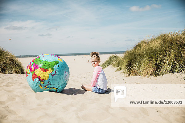 Mädchen mit Globus am Strand