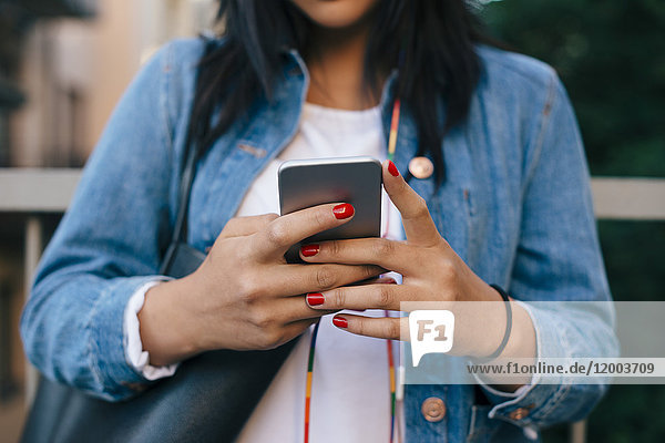 Midsection of teenage girl using smart phone