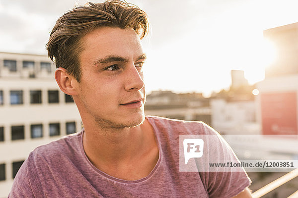 Portrait of young man on rooftop at sunset