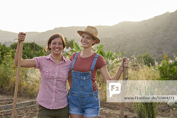 Portrait von zwei glücklichen Bauern mit Schaufeln