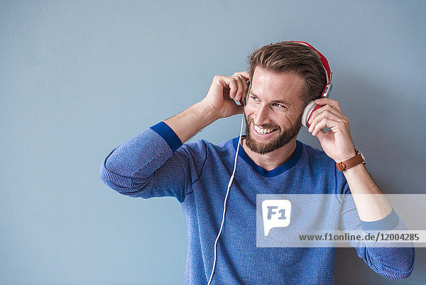 Lächelnder Mann beim Musikhören mit Kopfhörern