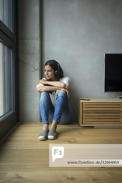 Entspannte Frau beim Musikhören zu Hause
