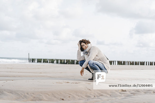 Woman crouching on the beach