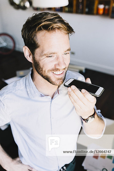 Portrait of smiling businessman using cell phone