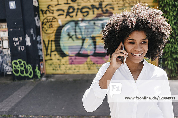 Lächelnde junge Frau am Handy im Freien
