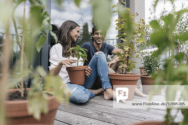 Glückliches Paar mit Pflanzen auf dem Balkon