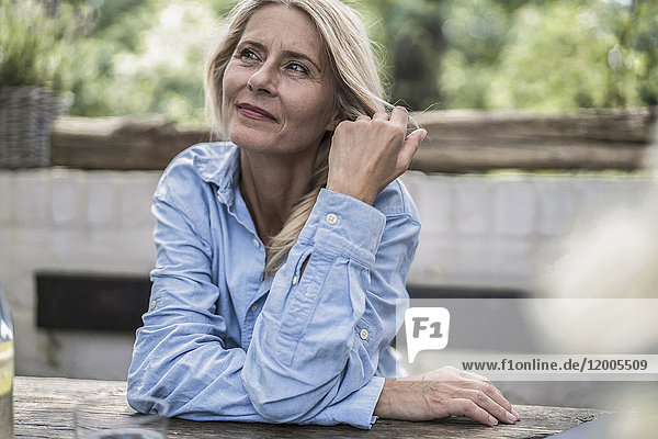 Mature woman sitting on terrace  thinking