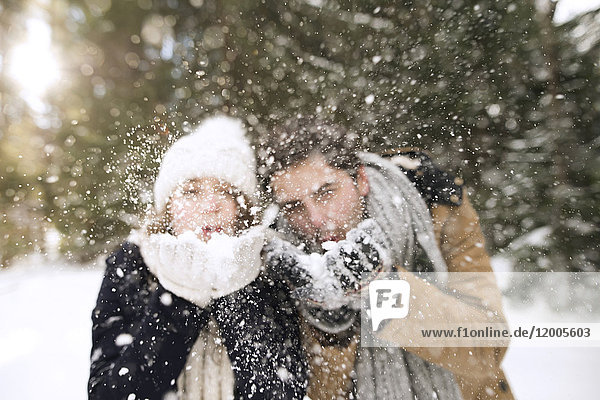 Young couple blowing snow