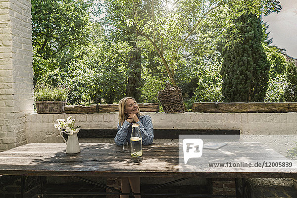 Mature woman sitting on terrace  enjoying summer