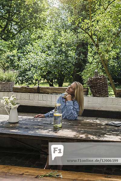 Reife Frau auf der Terrasse sitzend  den Sommer genießend