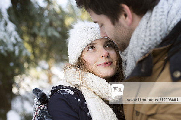 Portrait der glücklichen jungen Frau von Angesicht zu Angesicht mit ihrem Partner im Winter