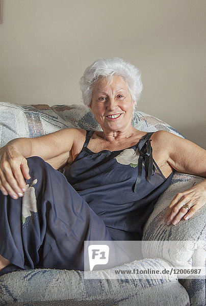 Porträt einer lächelnden kaukasischen Frau auf dem Sofa