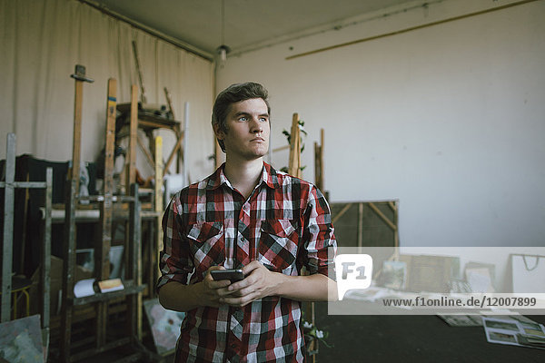 Pensive Caucasian man texting on cell phone