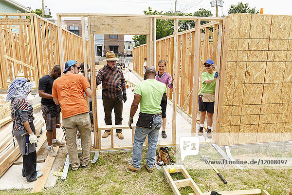 Volunteers holding wall at construction site