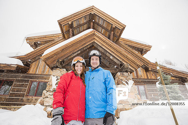 Porträt eines lächelnden kaukasischen Paares im Winterurlaub