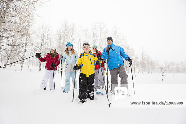 Porträt einer lächelnden kaukasischen Familie beim Schneeschuhwandern