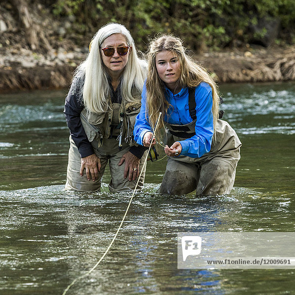 Caucasian mother and daughter fly fishing