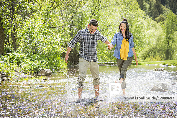 Woman kicking water on man in river