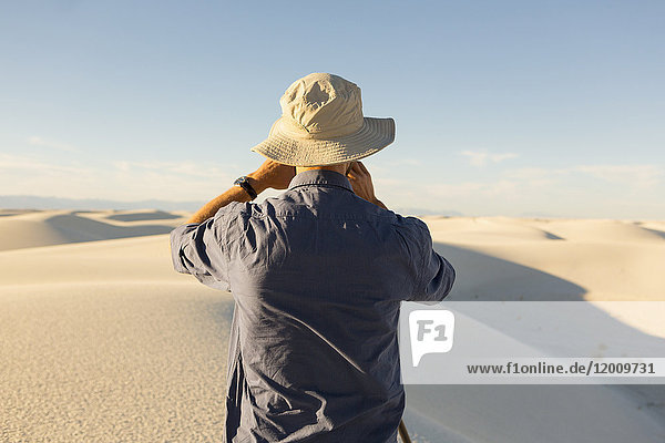 Caucasian man photographing a desert landscape