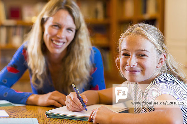 Portrait of Caucasian teacher helping student in library