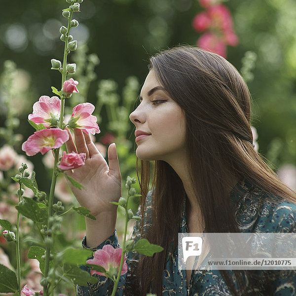 Kaukasische Frau bewundert rosa Blumen