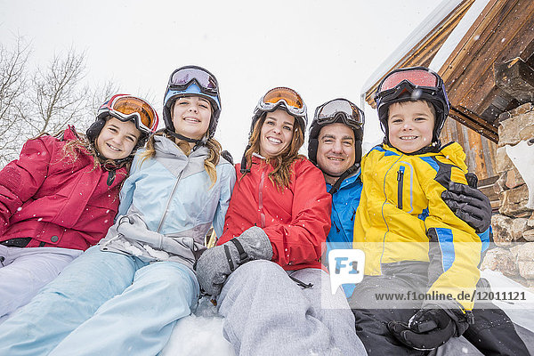 Porträt einer lächelnden kaukasischen Familie im Winterurlaub