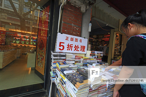 Asien  China  Shanghai. Chinesisches Mädchen schaut sich Bücher an